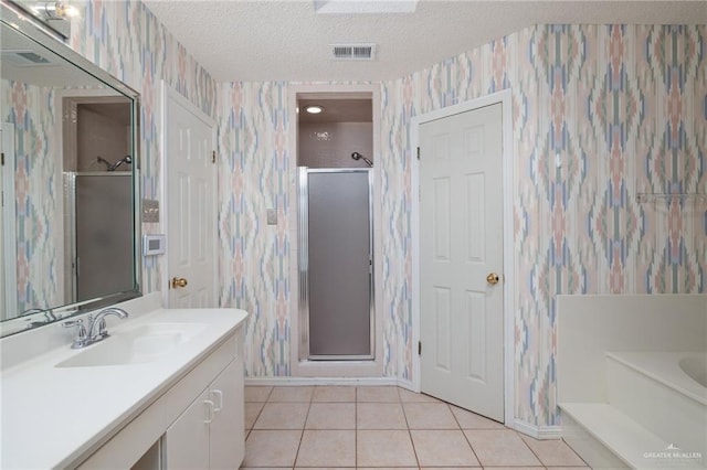 bathroom featuring a textured ceiling, a shower stall, tile patterned flooring, and wallpapered walls