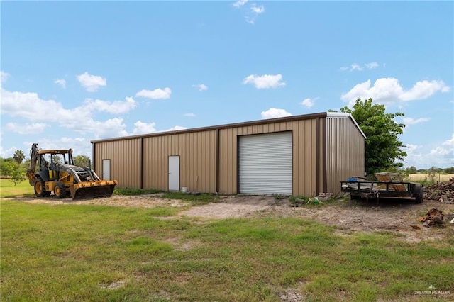 view of outdoor structure with a lawn and a garage