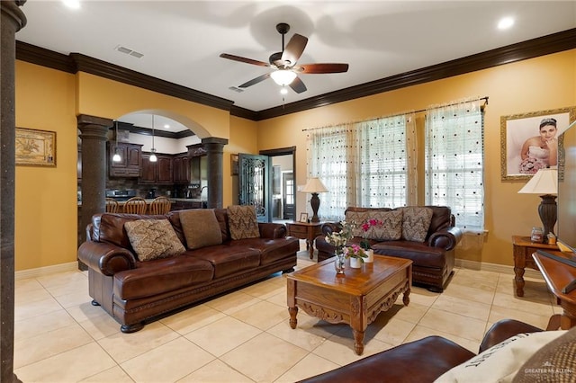 tiled living room with decorative columns, crown molding, and ceiling fan