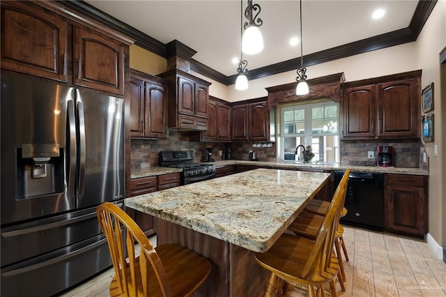 kitchen featuring black appliances, a center island, light wood-type flooring, and backsplash