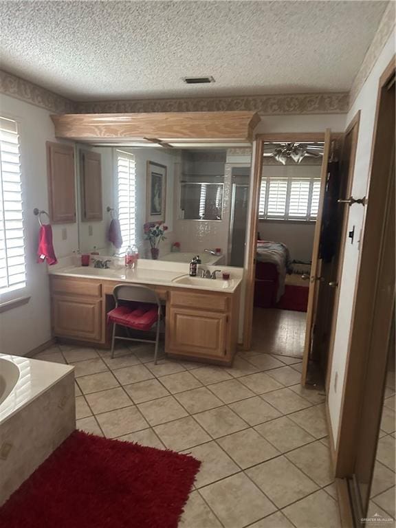 bathroom featuring tile patterned flooring, vanity, and a textured ceiling