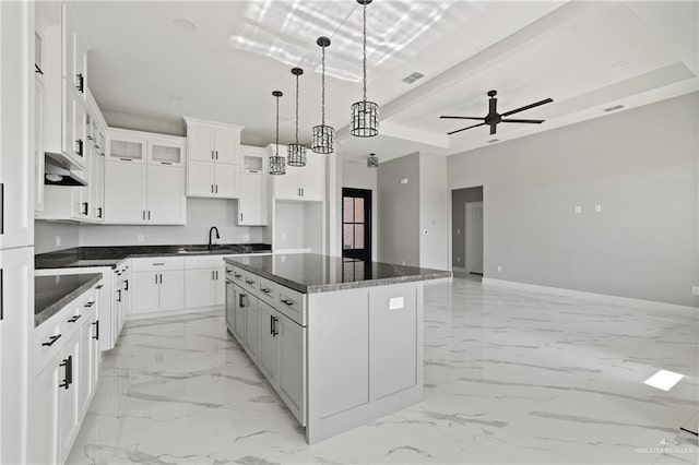 kitchen with baseboards, visible vents, marble finish floor, and a sink