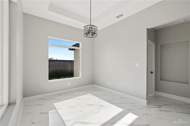 spare room featuring baseboards, marble finish floor, and a chandelier