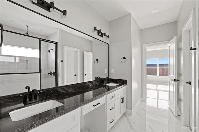 full bathroom featuring a shower stall, double vanity, marble finish floor, and a sink