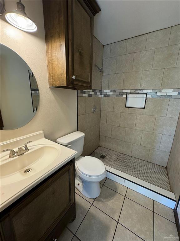 bathroom with vanity, a shower stall, toilet, and tile patterned flooring