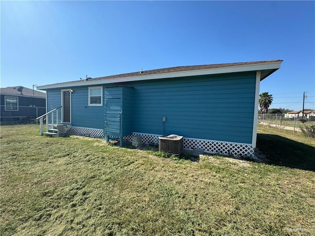 back of house with a yard, fence, central AC, and entry steps