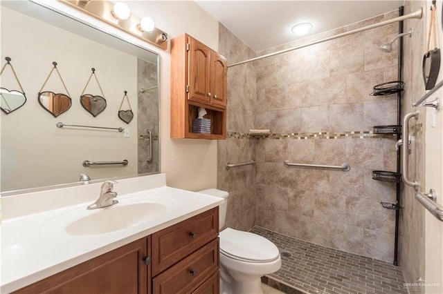 bathroom with tiled shower, vanity, and toilet