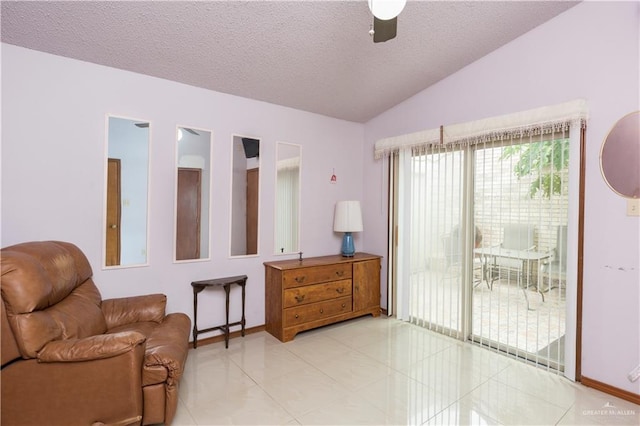 sitting room featuring light tile patterned floors, a textured ceiling, vaulted ceiling, and ceiling fan