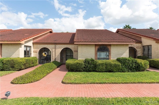 mediterranean / spanish-style home with a front lawn