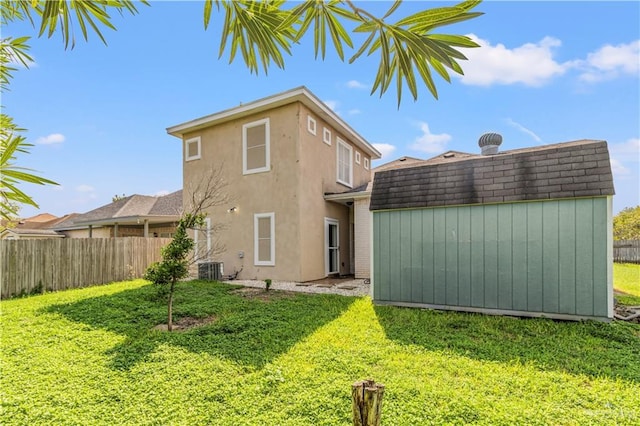 back of property featuring a lawn, a storage unit, and central air condition unit