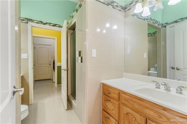 bathroom with tile patterned flooring, vanity, toilet, and walk in shower