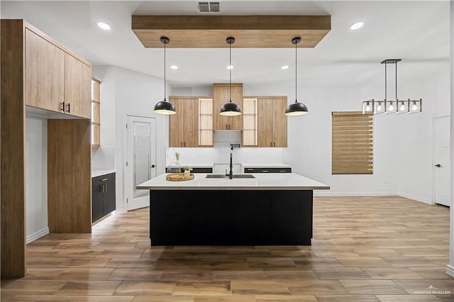 2413 N Woody St, Edinburg, TX 78541 - kitchen featuring light countertops, light wood-type flooring, modern cabinets, recessed lighting, and a center island with sink