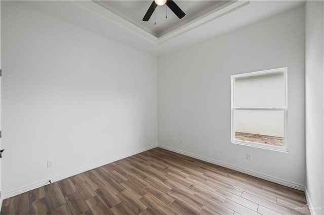 2413 N Woody St, Edinburg, TX 78541 - empty room featuring a tray ceiling, wood finished floors, and a ceiling fan