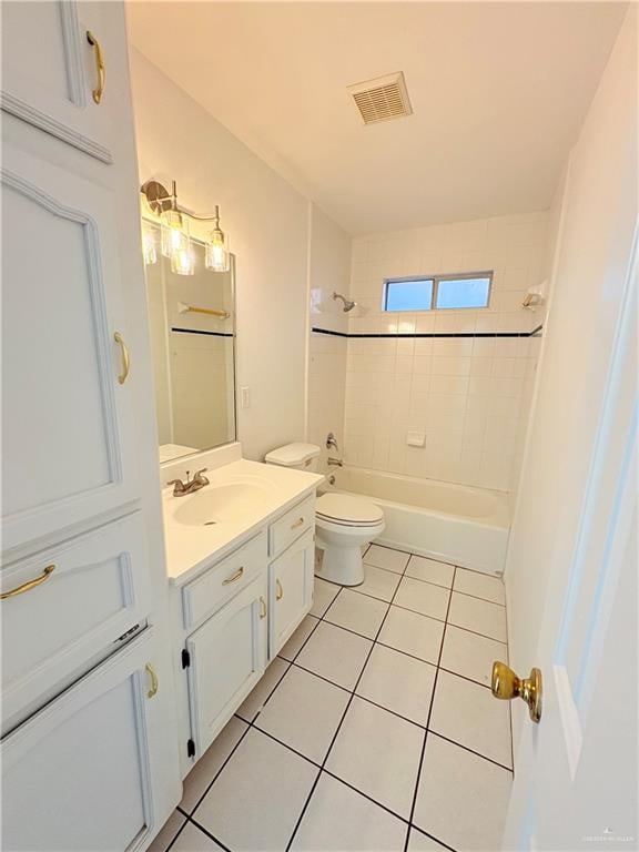 full bathroom with tile patterned flooring, vanity, tiled shower / bath combo, and toilet