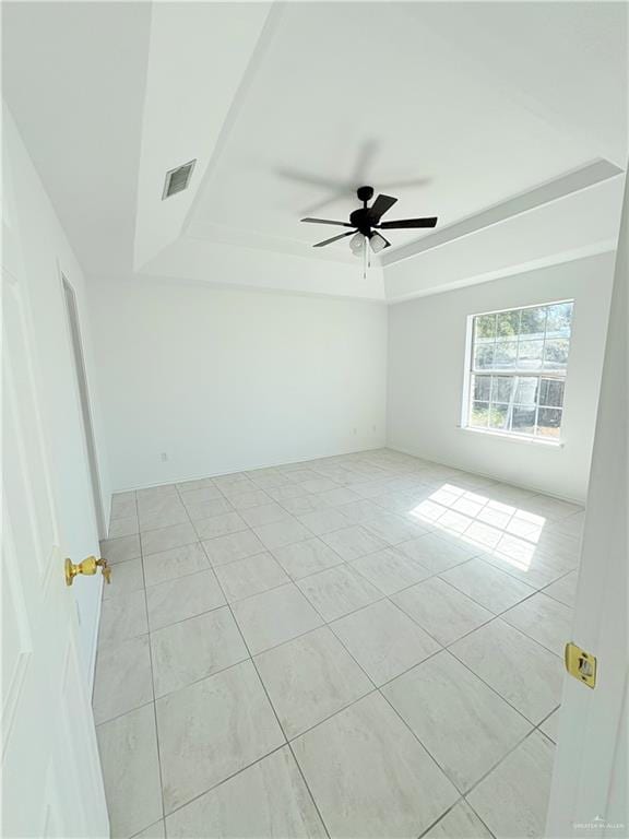 spare room with ceiling fan and light tile patterned floors