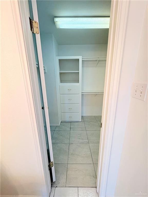 walk in closet with light tile patterned flooring