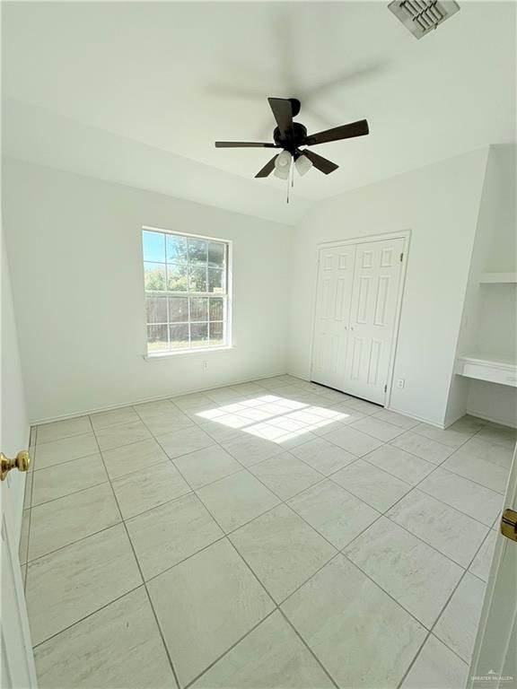 unfurnished bedroom featuring light tile patterned floors, a closet, and ceiling fan