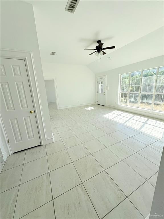 empty room with ceiling fan, light tile patterned floors, and lofted ceiling