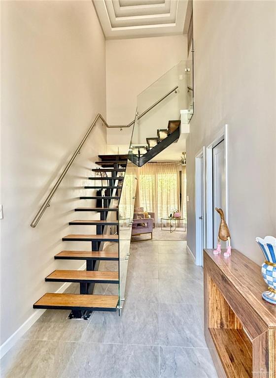 1925 Sunset Dr, Mission, TX 78572 - staircase with a towering ceiling and baseboards