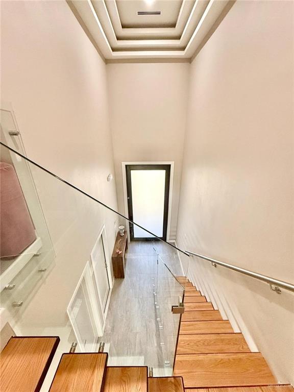 1925 Sunset Dr, Mission, TX 78572 - stairs featuring wood finished floors, a tray ceiling, and crown molding