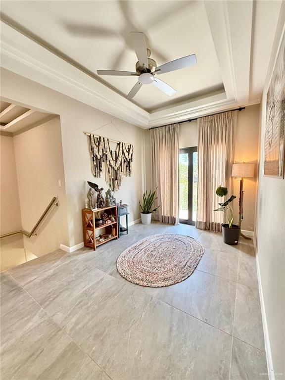 1925 Sunset Dr, Mission, TX 78572 - sitting room with a raised ceiling, baseboards, ceiling fan, tile patterned floors, and an upstairs landing
