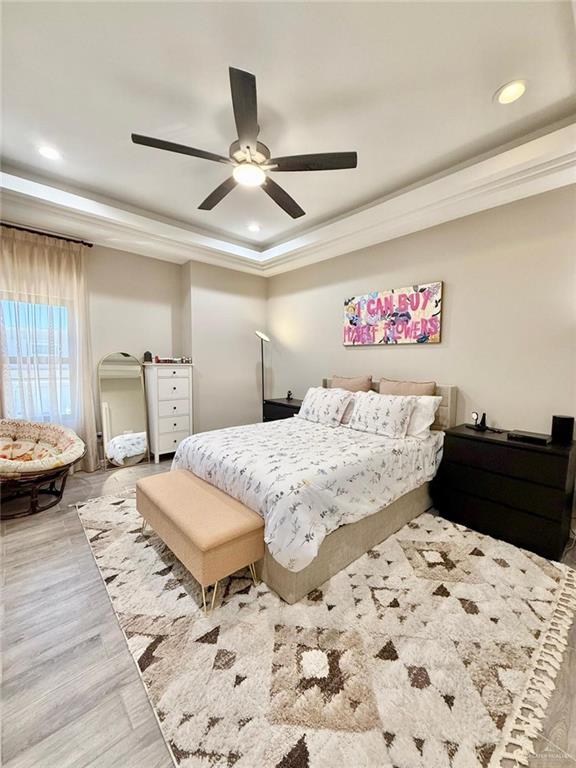 1925 Sunset Dr, Mission, TX 78572 - bedroom featuring a tray ceiling, wood finished floors, recessed lighting, and ceiling fan
