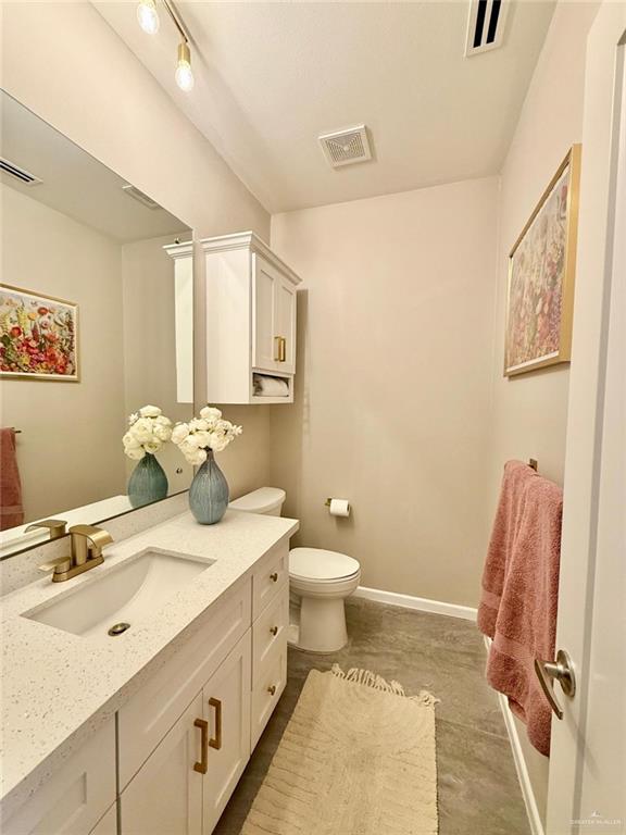 1925 Sunset Dr, Mission, TX 78572 - bathroom featuring toilet, vanity, and baseboards