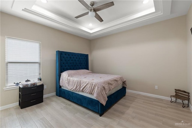 bedroom featuring baseboards, ceiling fan, recessed lighting, light wood-style flooring, and a raised ceiling