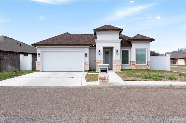 view of front of home with fence, stucco siding, driveway, stone siding, and an attached garage