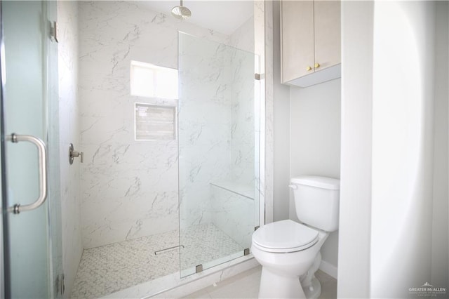 bathroom with a shower with shower door and toilet