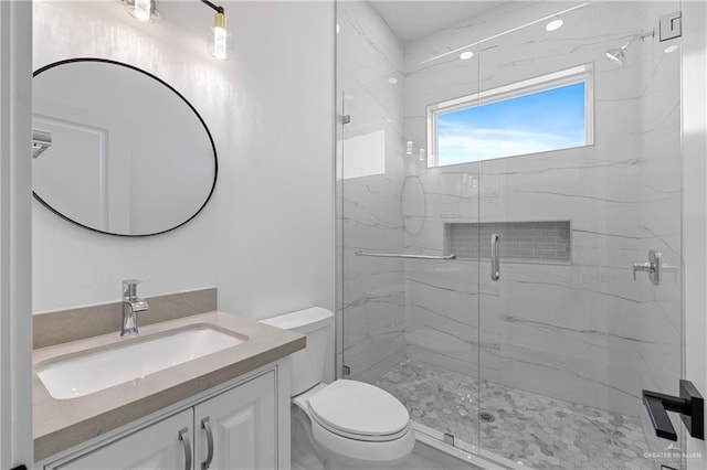 bathroom with walk in shower, vanity, and toilet