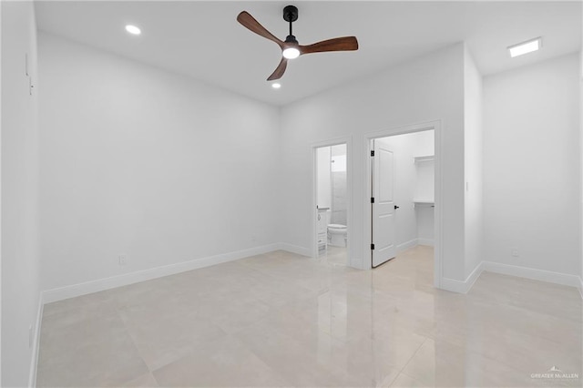 interior space with a closet, a walk in closet, connected bathroom, and ceiling fan