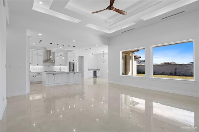 unfurnished living room featuring ceiling fan and sink