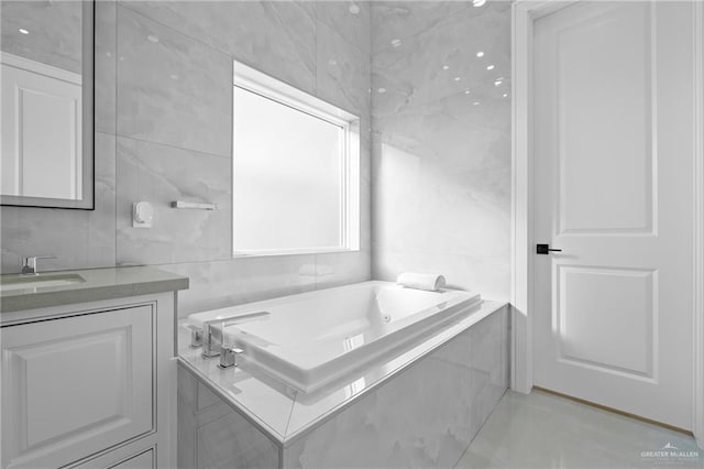 bathroom with a relaxing tiled tub, tile walls, and vanity