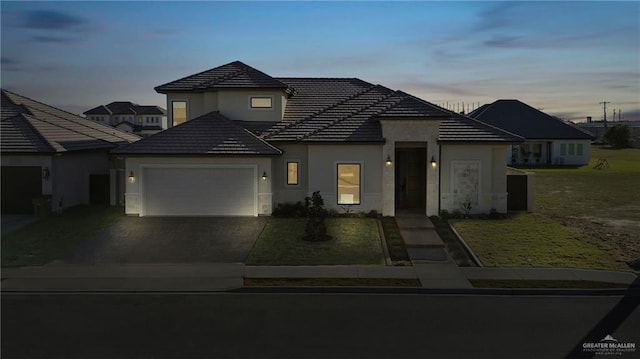 view of front facade featuring a garage and a lawn