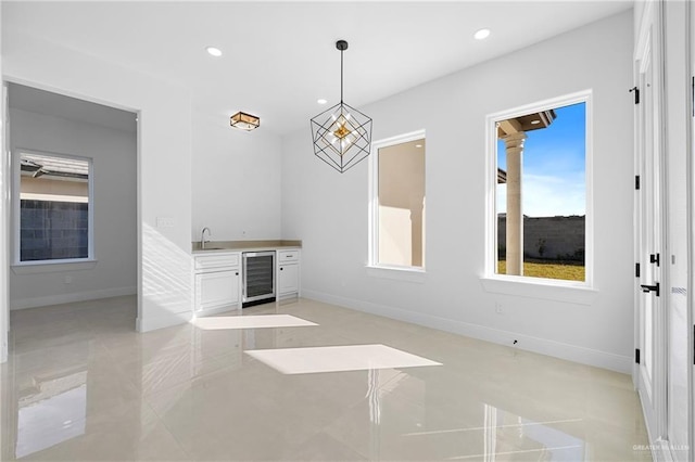 spare room featuring sink, light tile patterned floors, and wine cooler