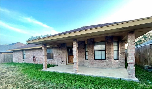 back of property featuring a lawn and a patio area