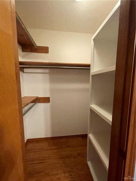 walk in closet with dark hardwood / wood-style flooring