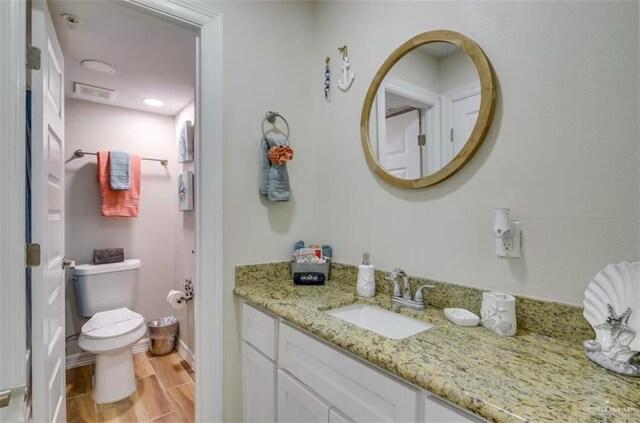 200 Padre Blvd Unit 2102, South Padre Island, TX 78597 - bathroom featuring visible vents, toilet, wood tiled floor, baseboards, and vanity