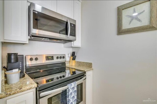200 Padre Blvd Unit 2102, South Padre Island, TX 78597 - kitchen featuring light stone counters, appliances with stainless steel finishes, and white cabinets
