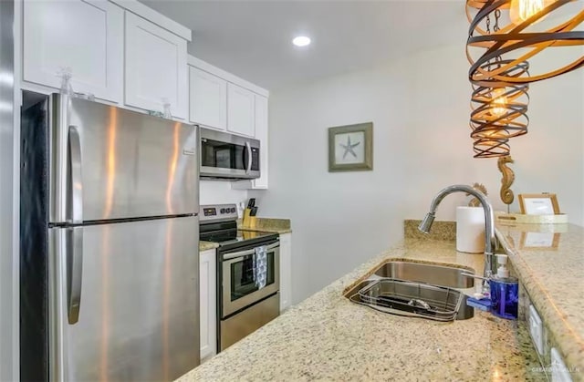 200 Padre Blvd Unit 2102, South Padre Island, TX 78597 - kitchen with white cabinets, light stone countertops, appliances with stainless steel finishes, and a sink