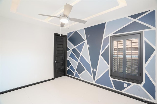 empty room featuring ceiling fan and a tray ceiling