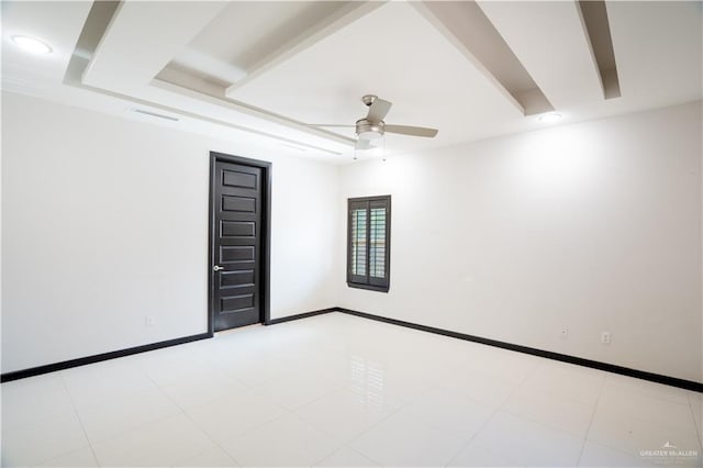 tiled spare room with a raised ceiling and ceiling fan