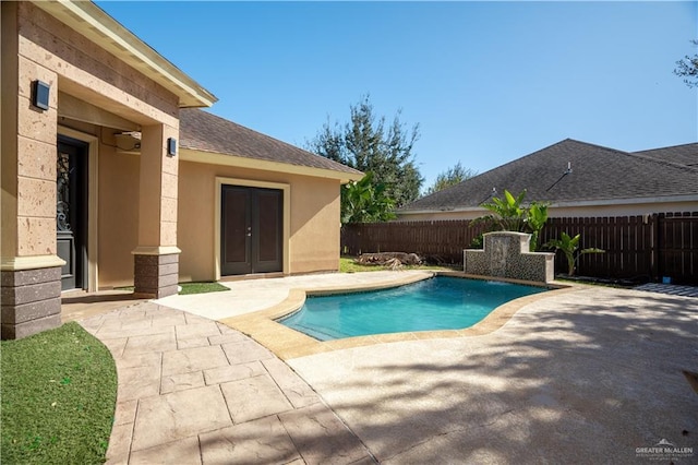 view of swimming pool with french doors and a patio