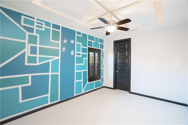 empty room featuring ceiling fan and a raised ceiling