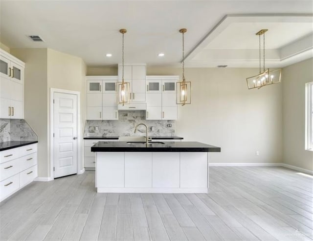 kitchen with pendant lighting, backsplash, sink, light hardwood / wood-style flooring, and white cabinetry