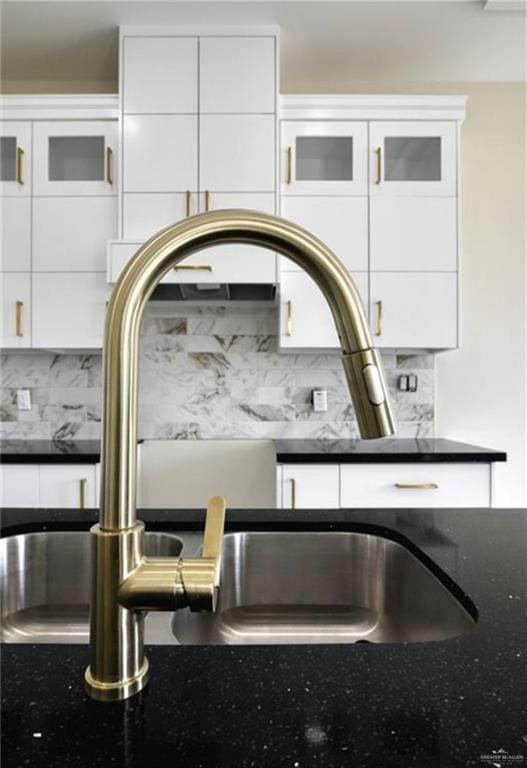 details with backsplash, white cabinetry, and sink