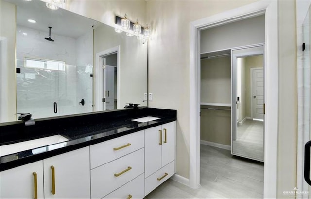 bathroom featuring vanity and a shower with door