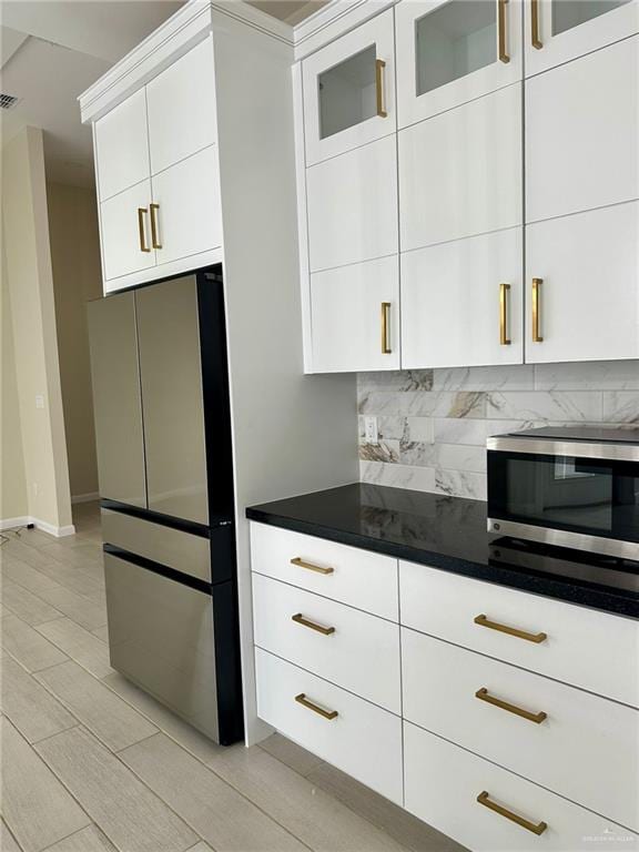 kitchen featuring backsplash, stainless steel appliances, and white cabinetry