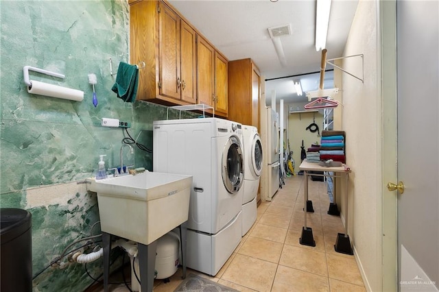 501 Capricorn St, Mission, TX 78572 - washroom with washer and clothes dryer, a sink, light tile patterned flooring, visible vents, and cabinet space